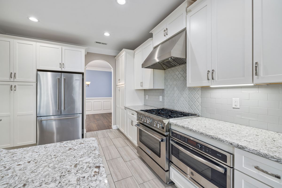 Custom subway-tile kitchen backsplash with a decorative arabesque accent behind the range