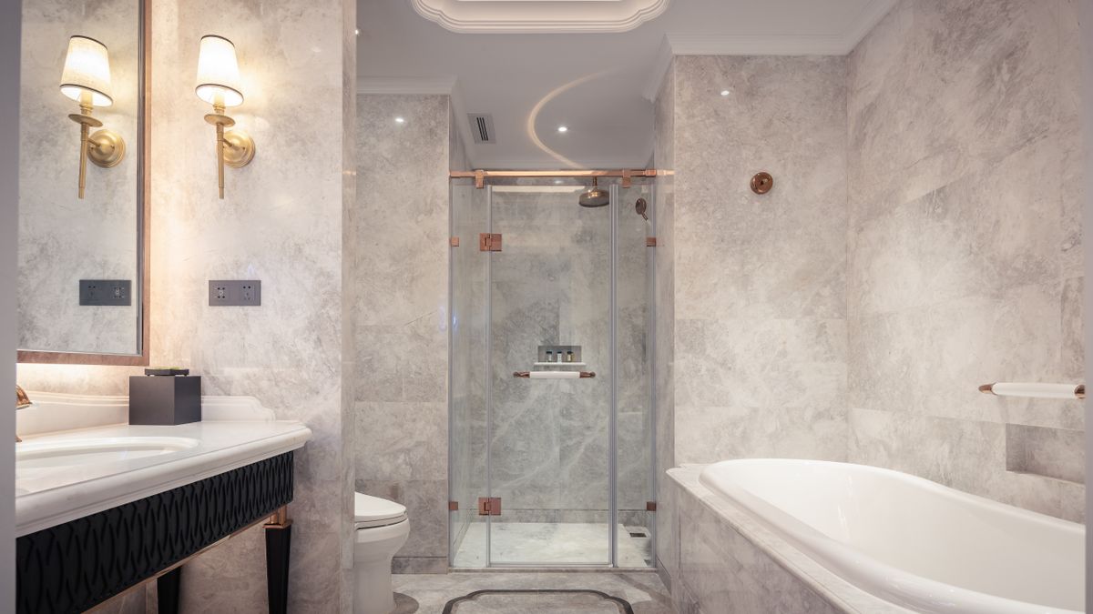 Light grey marble bathroom remodel with glass shower and tub